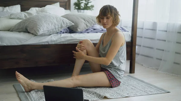 Fiatal, vonzó nő csinálás jóga gyakorlás és oktató leckét a hordozható számítógépet otthon néz — Stock Fotó