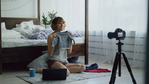Vonzó vidám nő közelében ágy felvétel videó blog gyermek ruhák dslr fényképezőgép otthon ült — Stock Fotó