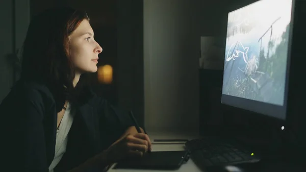 Geconcentreerde jonge vrouw designer werkzaam in kantoor nachts met behulp van computer en grafisch tablet klus — Stockfoto