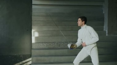Genç egzersizleri eskrim ve rekabete kapalı Studio eğitim fencer adam uygulama konsantre
