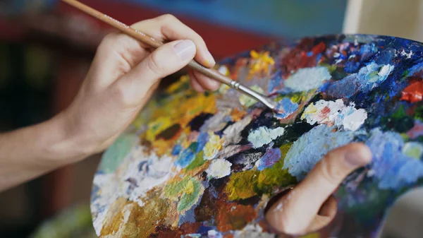 Gros plan de peintures à la main pour femmes avec pinceau dans la palette dans la classe d'art — Photo