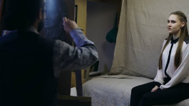 Yetenekli heykeltıraş Sanat stüdyosu modelinde poz kadının yüzünü oluşturmak için tuval üzerine hamuru ile çalışır