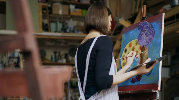 Getalenteerde jonge vrouw kunstenaar schilderij foto op canvas in de kunst-klasse — Stockfoto