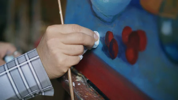 Крупним планом художники рука обмазують олійними фарбами на полотні картини в художній майстерні — стокове фото