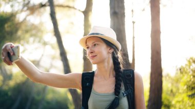 Selfie akıllı telefon fotoğraf makinesi ile seyahat ve otostop sırasında çekim şapkalı komik turist kız
