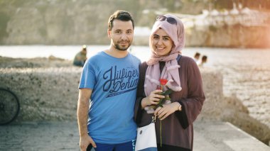 Antalya, Türkiye - 18 Ağustos 2017: Kameraya bakarak ve ilk tarihte gülümseyen genç Arap sevgi dolu çift portresi