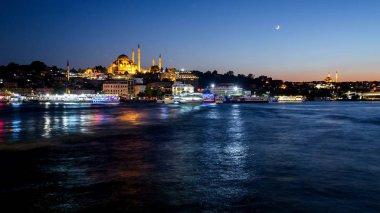 Istanbul cityscape turist ile Süleymaniye Camii ile boğaz geceleri yüzen gemi