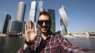 Uluslararası İş Merkezi Moskova yakınlarındaki onun smartphone kamera kullanarak online görüntülü sohbet sahip mutlu turist adam
