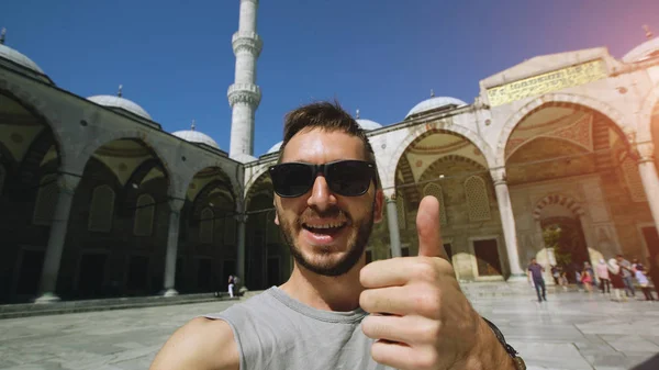 Palmare di felice turista uomo avendo video chat online utilizzando la sua fotocamera smartphone vicino alla famosa moschea blu di Istanbul — Foto Stock