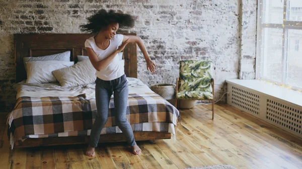 Atraente misto raça jovem alegre mulher se divertir dançando perto da cama em casa — Fotografia de Stock