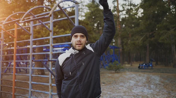 Joven atleta hombre calentando antes de entrenar en el parque de invierno —  Fotos de Stock