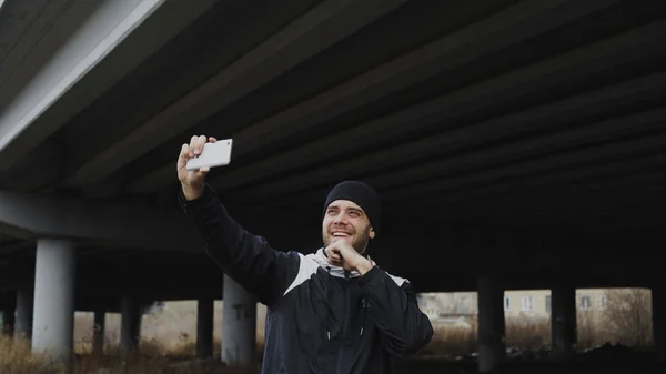 Happy sportive man taking selfie portrait with smartphone after training in urban outdoors location in winter — Stock Photo, Image