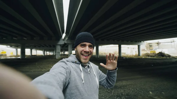 POV of sportive man having video chat on smartphone with friends after workout at urban location outdoors in winter — Stock Photo, Image