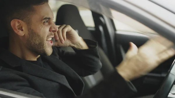 Крупный план стрессового бизнесмена, ругающегося и говорящего по телефону, сидящего в машине на улице — стоковое фото