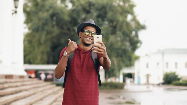 Étudiant afro-américain ayant chat vidéo en ligne en utilisant sa caméra smartphone à l'extérieur — Photo
