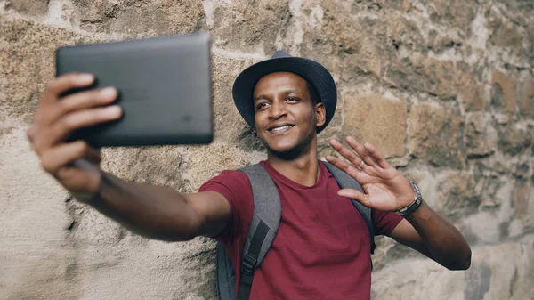 युरोप मध्ये प्रवास करताना टॅबलेट संगणक वापरून ऑनलाइन व्हिडिओ चॅट येत आनंदी आफ्रिकन अमेरिकन पर्यटक मनुष्य — स्टॉक फोटो, इमेज