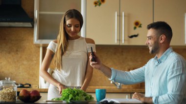 Çekici çift erken sabah mutfakta ve tablet bilgisayar kullanarak online video sohbet
