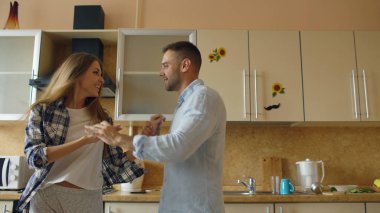 Çekici genç komik çift evde mutfakta yemek yaparken dans eğlenceli