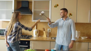 Mutfakta kahvaltı evde pişirme sırasında kepçe ve kaşıkla eskrim eğleniyor çekici çift
