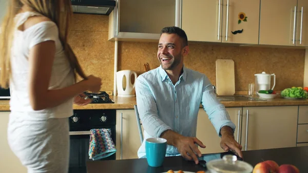 Ελκυστικό ζευγάρι συναντηθούν στην κουζίνα νωρίς το πρωί και χρησιμοποιώντας υπολογιστή ψηφιακή δισκίο για την κοινωνική media σερφ — Φωτογραφία Αρχείου