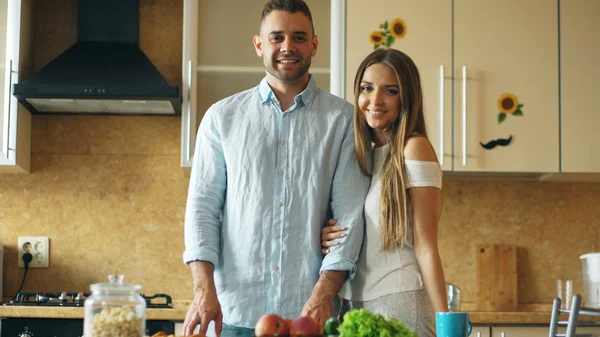 Retrato de pareja amorosa sonriendo ang mirando a la cámara en la cocina en casa — Foto de Stock