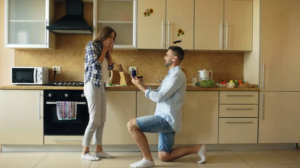 Молодий чоловік робить пропозицію своїй дівчині на кухні вдома — стокове фото