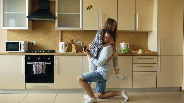 Joven haciendo proposición a su novia en la cocina en casa — Foto de Stock