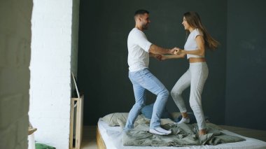 Genç güzel ve sevgi dolu bir çift yatakta sabah dans