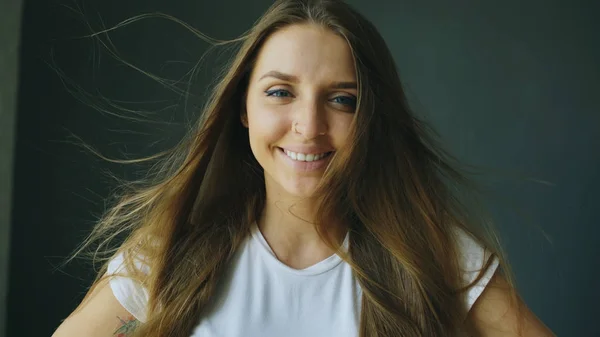 Portrait of young smiling woman with hair flying of wind — Stock Photo, Image