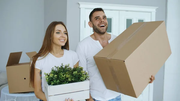Young happy couple talking while standing at their new house — Stock Photo, Image