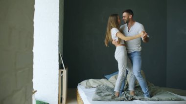 Genç güzel ve sevgi dolu bir çift yatakta sabah dans
