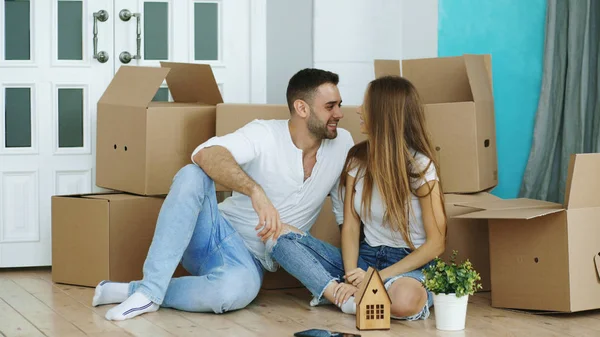 Lyckliga paret sitter på golvet i nya hus — Stockfoto