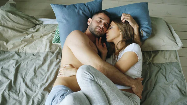 Young beautiful and loving couple kissing on bed in the morning — Stock Photo, Image