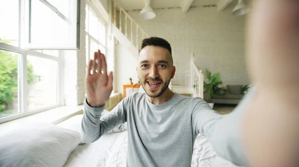 Junger bärtiger Mann mit Tablet-Computer und Video-Chat zu Hause im Bett — Stockfoto