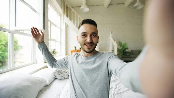 Junger bärtiger Mann mit Tablet-Computer und Video-Chat zu Hause im Bett — Stockfoto
