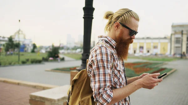 Vousatý turistické muž ztratil v městě a pomocí smartphone online mapy najít správným směrem — Stock fotografie