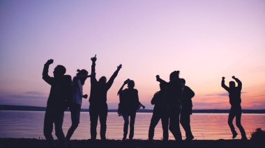 Grup genç insanlar dans silüeti on sunset beach adlı bir parti var