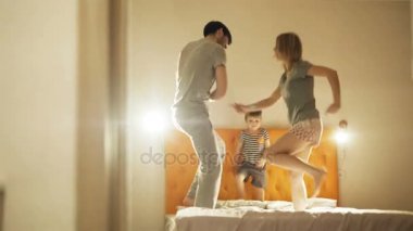 Dans küçük oğluyla mutlu aile ve akşam yatmadan önce yatağa evde eğlenin