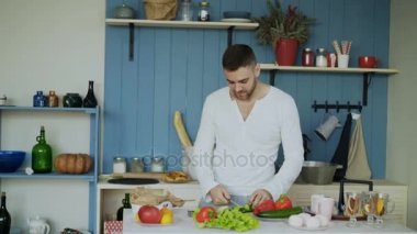 Mutlu genç çift mutfakta. Onun girfriend yemek çekici dans eden adam gelip onu sabah yardım