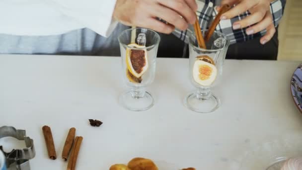 Närbild av par händer blandning av kryddor i ett glas för glögg i köket hemma — Stockvideo