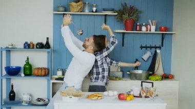 Mutlu genç çift eğlenceli dans ve şarkı mutfak sabahları evde müzik dinlerken var