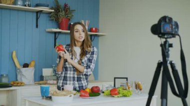 Neşeli çekici kadın evde mutfak vejetaryen sağlıklı gıda dslr fotoğraf makinesi ile ilgili video blog kayıt