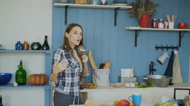 Dans ve evde mutfakta şarkı neşeli genç komik kadın