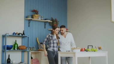 Çekici genç neşeli çift evde mutfakta yemek yaparken dans eğlenceli