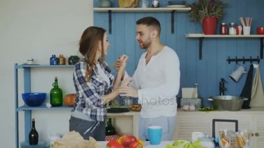 Neşeli ve çekici genç çift birlikte tatil günlerinde mutfakta evde latin dans dans aşk