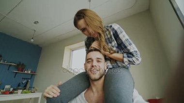 POV shot tatlı ve sevgi dolu çift konuşmak smartphone tutarak ve oturan kız evde boyun mans arkadaşlarıma programları online görüntülü sohbet