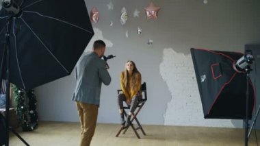 Genç güzel kadın model bir dijital kamera ile fotoğraf stüdyosu kapalı çekerken fotoğrafçısına poz