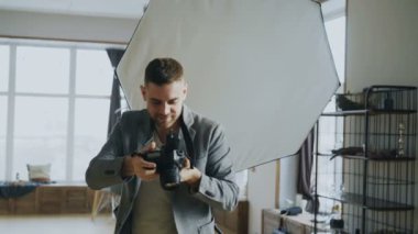 Genç adam fotoğrafçı çekim modelinin dijital kamerada fotoğraf stüdyosu çalışma