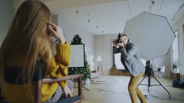 Fotógrafo profissional tirando fotos de modelo em câmera digital trabalhando em estúdio de fotografia — Vídeo de Stock