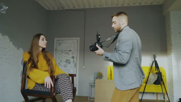 Professionell fotograf mannen att ta foto av vackra modell flicka med digitalkamera i studio — Stockvideo